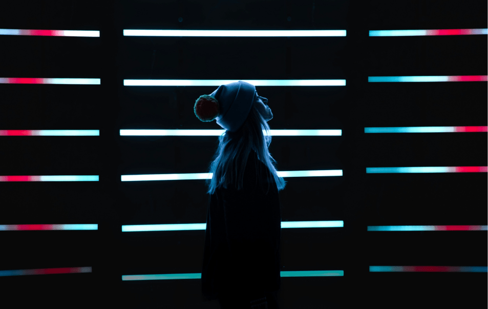 Female standing against colorful neon light backdrop