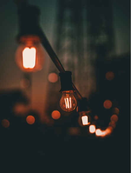 Illuminated light bulbs strung together in the dark.